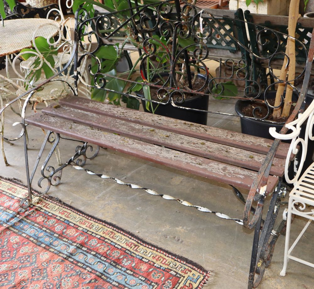 A wrought iron garden bench with slatted seat, W.136cm, D.approx. 74cm, H.110cm